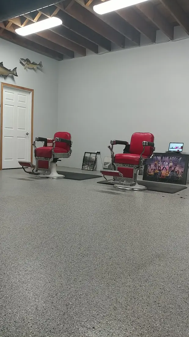 Two red vintage barber chairs in the bright shop